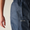 Close-up van de heup en arm van een persoon, donkerblauwe broek met zijzak en wit "Regatta Great Outdoors"-logo