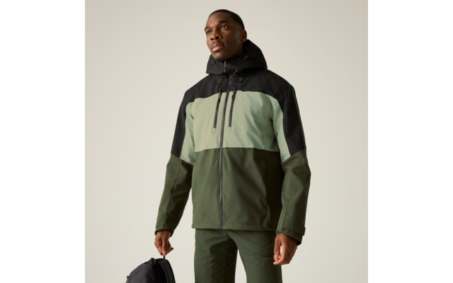 Person trägt dreifarbige Jacke mit Kapuze (schwarz, hellgrün, oliv), olivgrüne Hose, hält schwarzen Rucksack