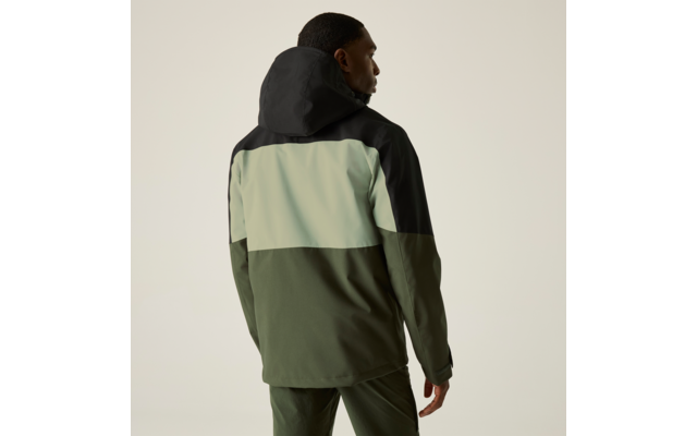 Person von hinten, trägt eine Kapuzenjacke mit schwarzer Kapuze, hellgrünem Mittelteil und olivgrünem Unterteil, vor beigem Hintergrund