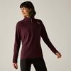Personne devant un fond gris clair portant un pull bordeaux à manches longues avec une fermeture éclair courte et un petit logo sur la poitrine gauche, legging noir, regard vers la gauche