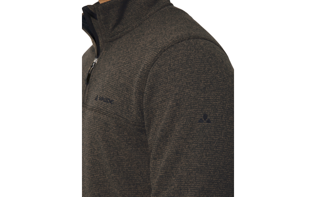 Nahaufnahme des Oberkörpers in einer dunklen, melierten Fleecejacke mit Reißverschluss, sichtbare Brusttasche mit Reißverschluss, Markenname VAUDE auf der Brust und kleines Logo auf dem Ärmel