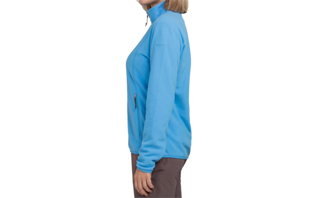 Frau von der Seite, trägt blaue Jacke und braune Hose