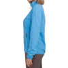 Frau von der Seite, trägt blaue Jacke und braune Hose