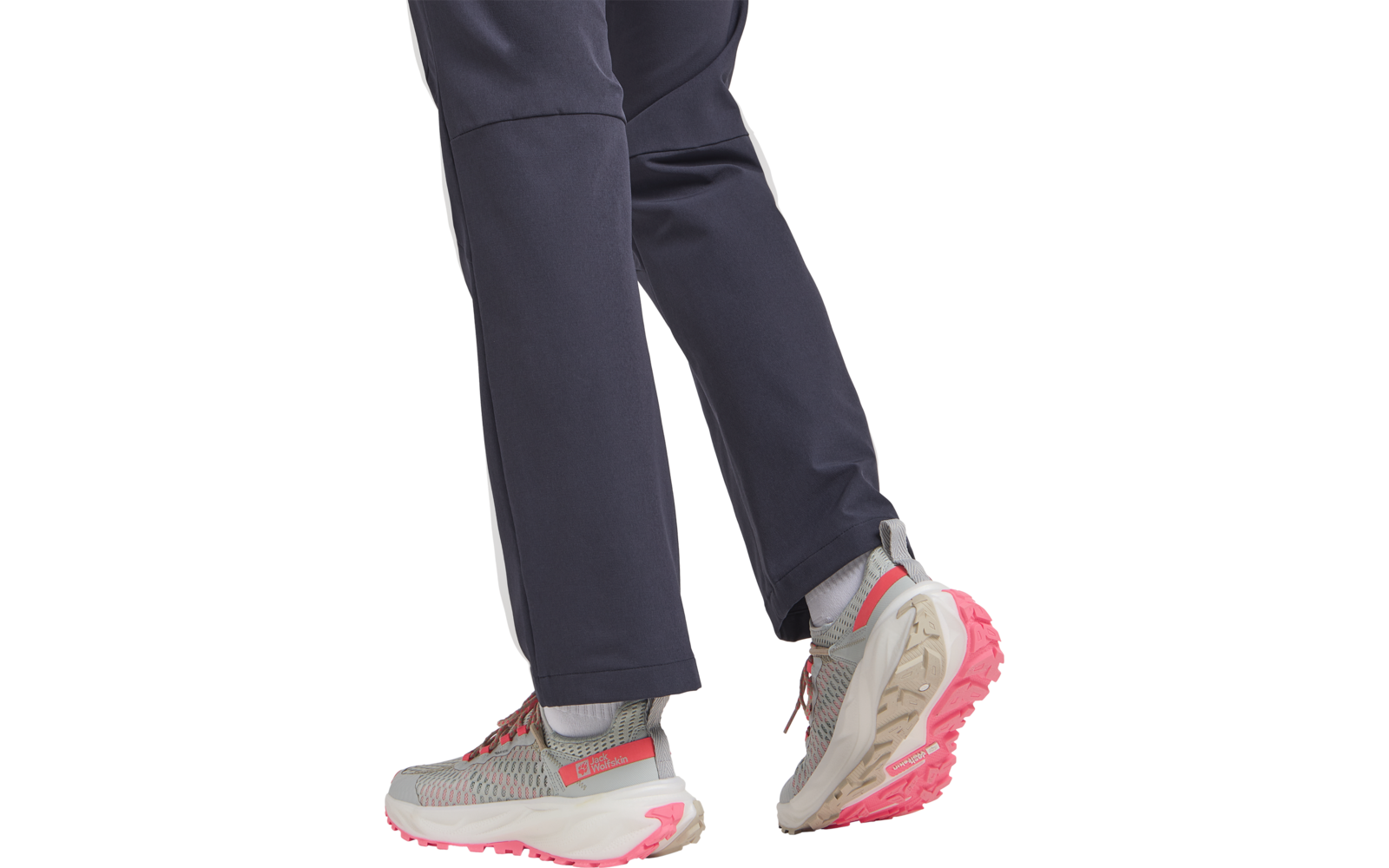 Beine einer Person mit dunkelblauer Hose und grauen Sneakers, die gerade gehen