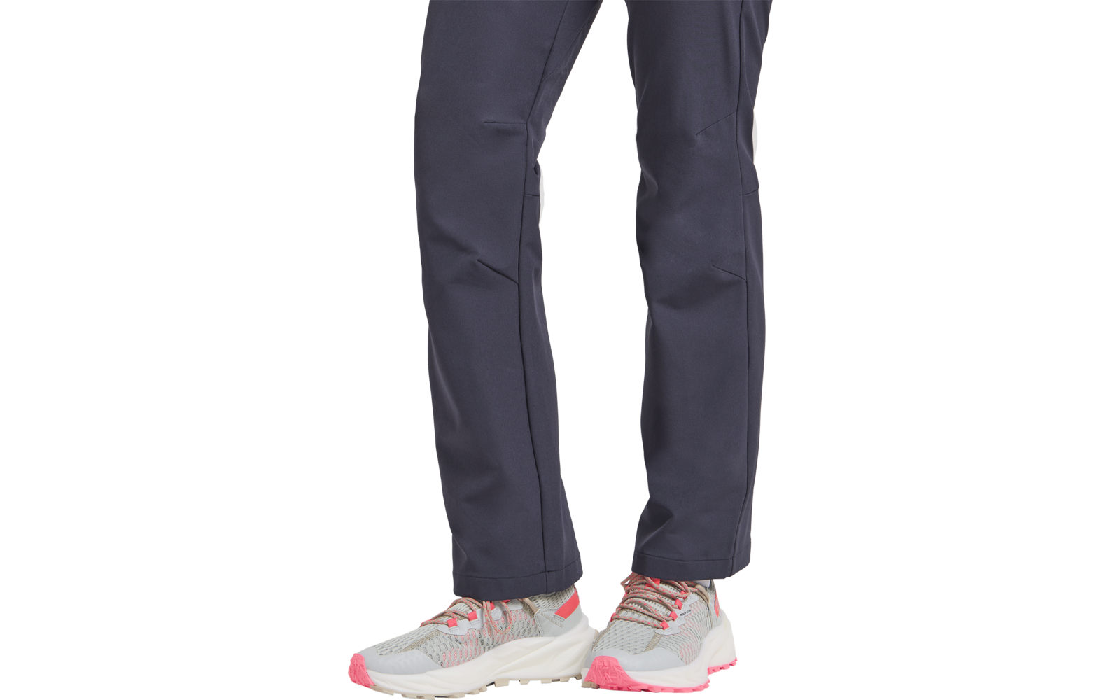 Beine in dunkelblauer Hose und hellgrauen Sportschuhen mit rosa Akzenten