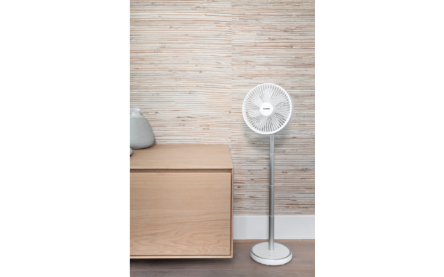 Ventilateur sur pied à droite, meuble en bois à gauche avec deux vases en céramique, mur avec lattes de bois horizontales, plinthe blanche