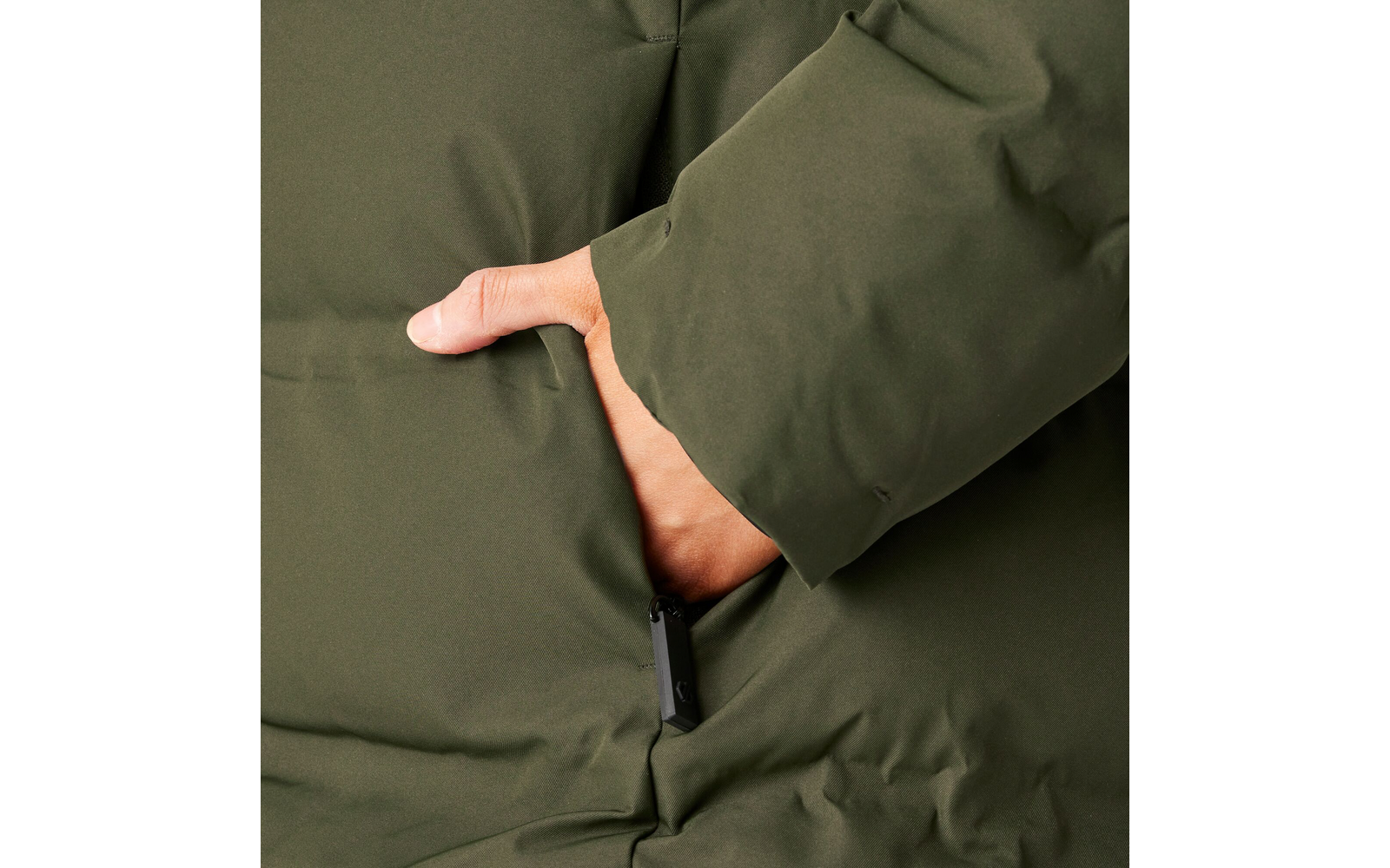 Hand in der Tasche eines grünen Wintermantels