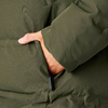 Hand in der Tasche eines grünen Wintermantels