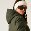 Frau mit Sonnenbrille, rosa Stirnband und grünem Wintermantel von der Seite