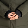 Hände verschränkt vor einer grünen Jacke