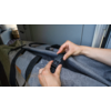 Hands fastening a black buckle on a gray bag