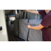 Person opening a gray bag inside a camper van