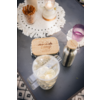 Plateau en bois avec bougies chauffe-plat et bougie sur une table grise, à côté un verre avec des glaçons, une paille en métal et un verre violet