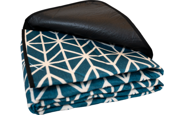 Gefaltete Decke mit türkis-blauer Oberfläche und weißem geometrischem Muster, schwarze Rückseite sichtbar