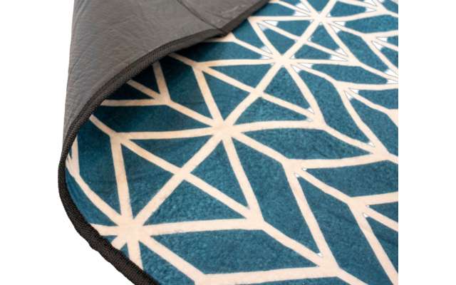 Runder Teppich mit umgeklappter Ecke, blau mit weißem geometrischem Muster, graue Unterseite und schwarzer Rand