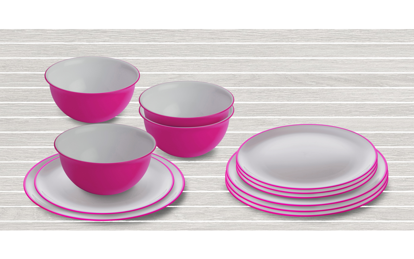 Drie roze-witte kommen op witte borden en vier gestapelde witte borden met roze rand op een lichte houten tafel