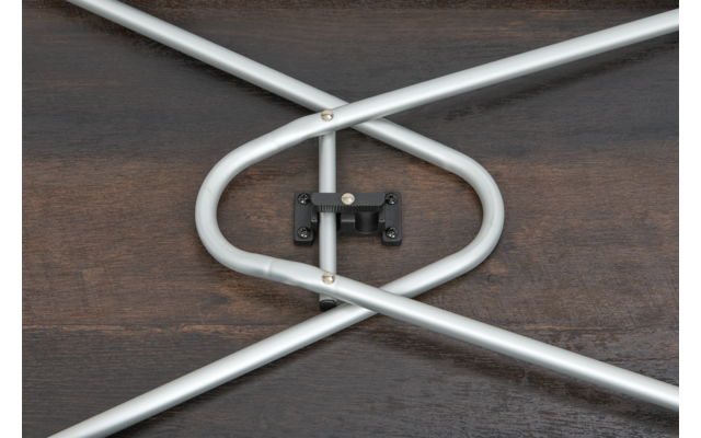 Tubes métalliques argentés croisés reliés par une charnière noire sur une surface en bois foncé