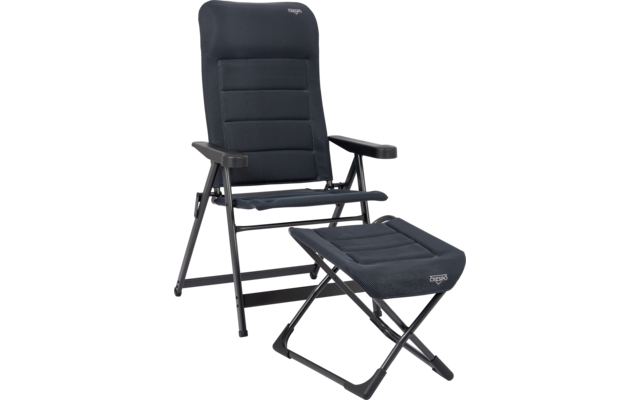 Klappbarer gepolsterter dunkelblauer Sessel mit Armlehnen und passendem klappbarem Fußhocker auf schwarzem Metallgestell