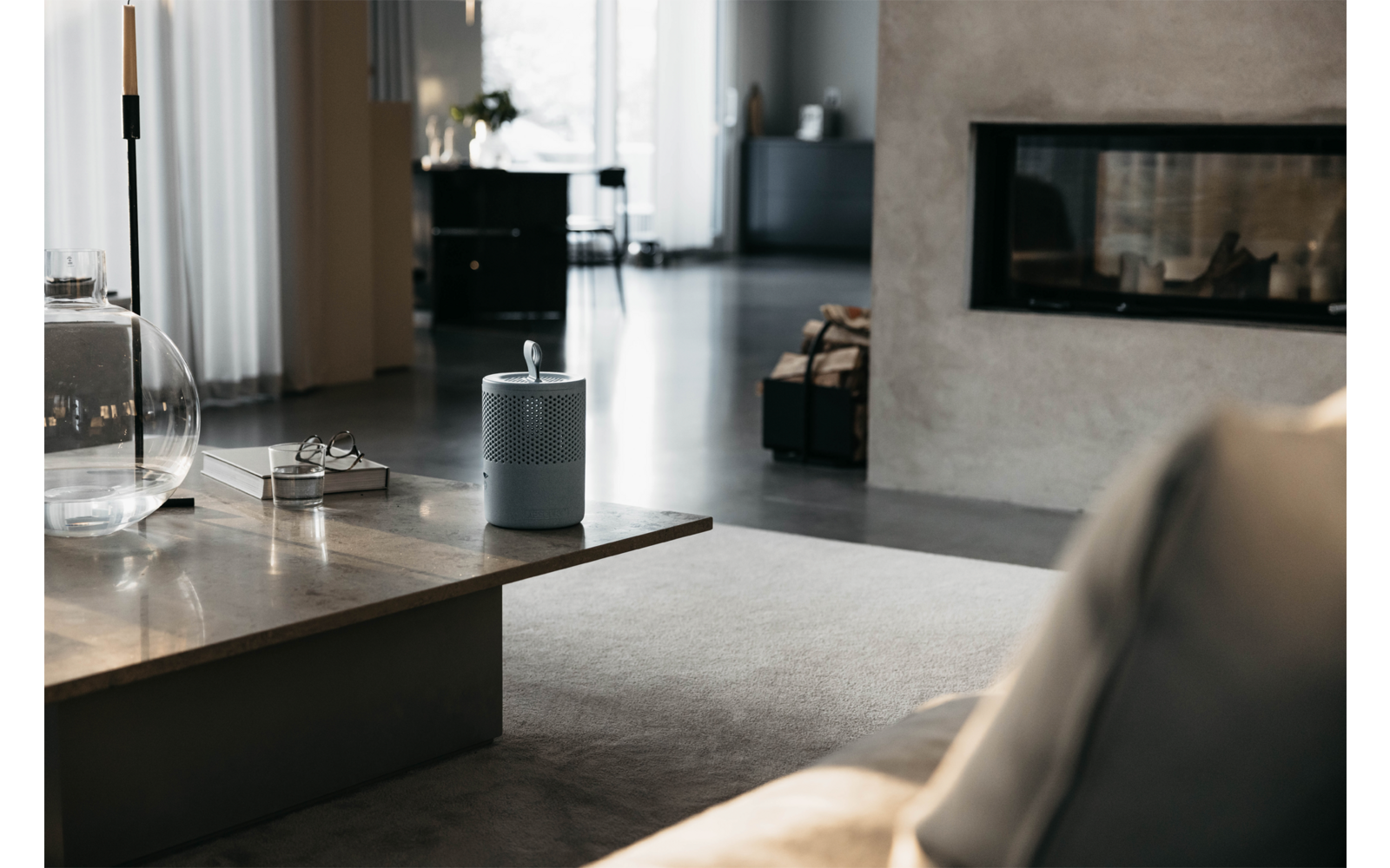 Moderner Wohnraum mit Sofa, Kamin und großen Fenstern