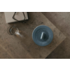 Blaue runde Luftbefeuchter auf einem Holztisch neben einem Glas Wasser