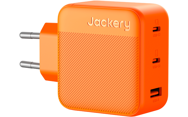 Orangener quadratischer Steckadapter mit zwei runden Metallstiften, geprägtem Schriftzug "Jackery", diagonaler Riffelung und drei seitlichen USB-Anschlüssen (zwei Typ-C, ein Typ-A)