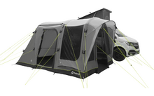 Furgone camper bianco con ampio tendalino gonfiabile grigio fissato al veicolo, più finestre e funi di ancoraggio verde brillante