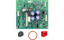 Placa de circuito impreso verde con numerosos componentes SMD, cuatro condensadores cilíndricos azules en el centro, un gran componente cilíndrico negro a la izquierda, conectores blancos en los lados y varios circuitos integrados; debajo tres piezas sueltas: pieza de plástico negra semicircular con abertura, bloque plástico rectangular rojo con agujero y una junta tórica naranja