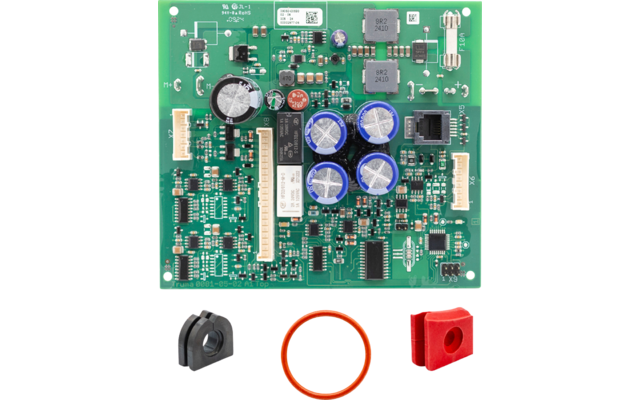 Placa de circuito impreso verde con numerosos componentes SMD, cuatro condensadores cilíndricos azules en el centro, un gran componente cilíndrico negro a la izquierda, conectores blancos en los lados y varios circuitos integrados; debajo tres piezas sueltas: pieza de plástico negra semicircular con abertura, bloque plástico rectangular rojo con agujero y una junta tórica naranja