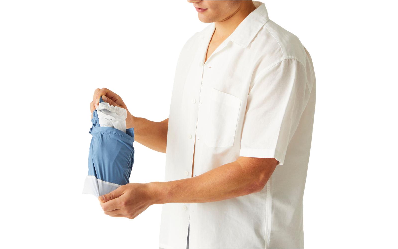 Personne en chemise blanche à manches courtes tenant un vêtement bleu et blanc plié