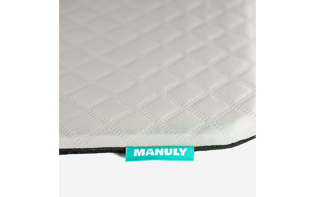 Nahaufnahme einer hellgrauen, gesteppten Oberfläche mit Rautenmuster und einem türkisen Stoffetikett mit der Aufschrift "MANULY" am unteren Rand