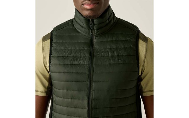 Bovenlichaam van een persoon tot aan de kin, met een donkergroene gewatteerde mouwloze bodywarmer met rits over een lichtgeel T-shirt met korte mouwen