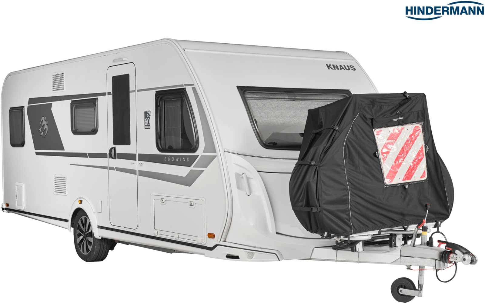 Weißer Wohnwagen, Deichsel mit schwarzer Abdeckung und rot-weißer Warnmarkierung, Seitenfenster und Eingangstür sichtbar