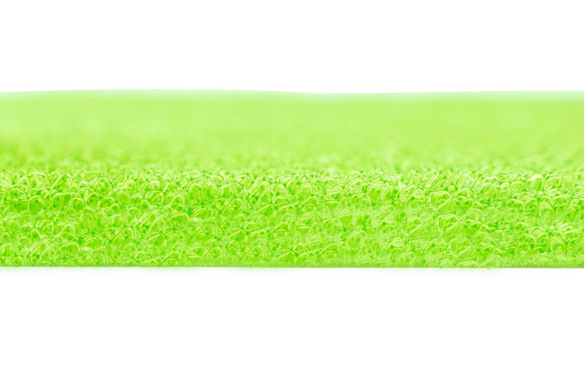 Primo piano di una superficie strutturata verde neon con fibre sottili e dense; inquadratura orizzontale