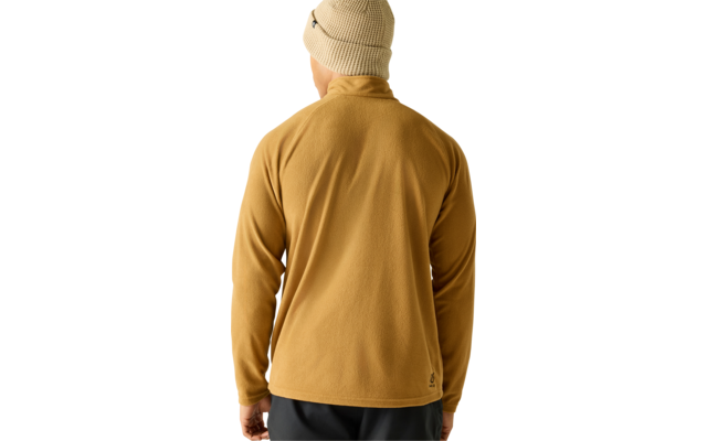 Persoon van achteren met beige gebreide muts, mosterdgele fleecejas en donkere broek voor een lichte achtergrond