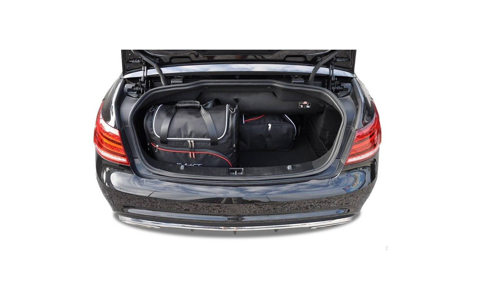 Coffre ouvert d'une voiture noire contenant un grand sac de voyage noir et un sac noir plus petit