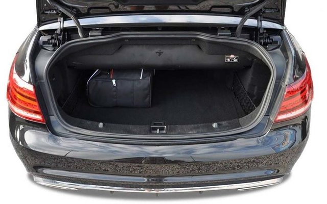 Coffre ouvert d'une voiture noire avec un petit sac de voyage noir sur le côté gauche