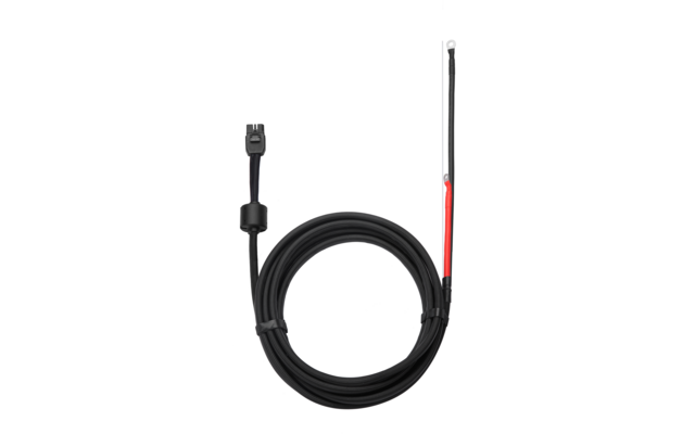 Schwarzes, aufgewickeltes Kabel; links zwei‑poliger schwarzer Stecker mit Ferritkern; rechts zwei offene Adern, eine rot isoliert mit Metallöse, eine schwarz isoliert