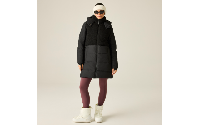 Person steht vor beigem Hintergrund, trägt schwarze gesteppte Kapuzen-Winterjacke mit Fleecebesatz, bordeauxfarbene Leggings, weiße hohe Winterstiefel, weißes Stirnband und schwarze Sonnenbrille