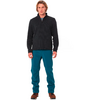 Ein Mann steht, trägt einen schwarzen Pullover, blaue Hose und braune Schuhe