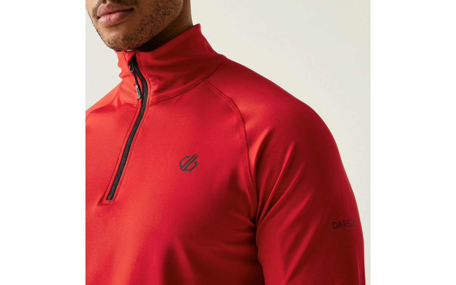 Bovenlichaam van een man met een rood shirt met lange mouwen en rits