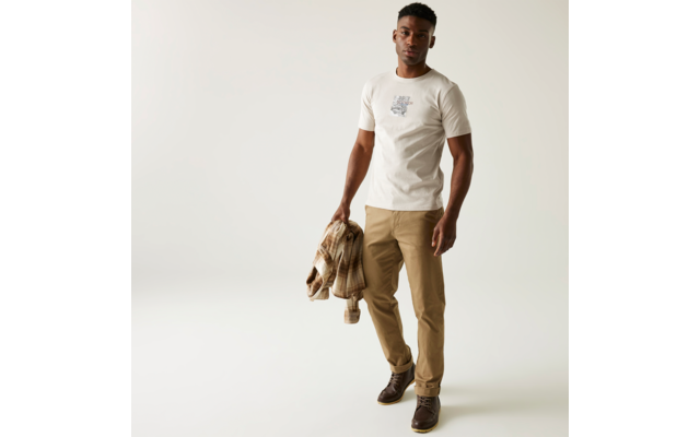 Mann mit weißem T-Shirt und hellbrauner Hose, der eine Jacke in der Hand hält