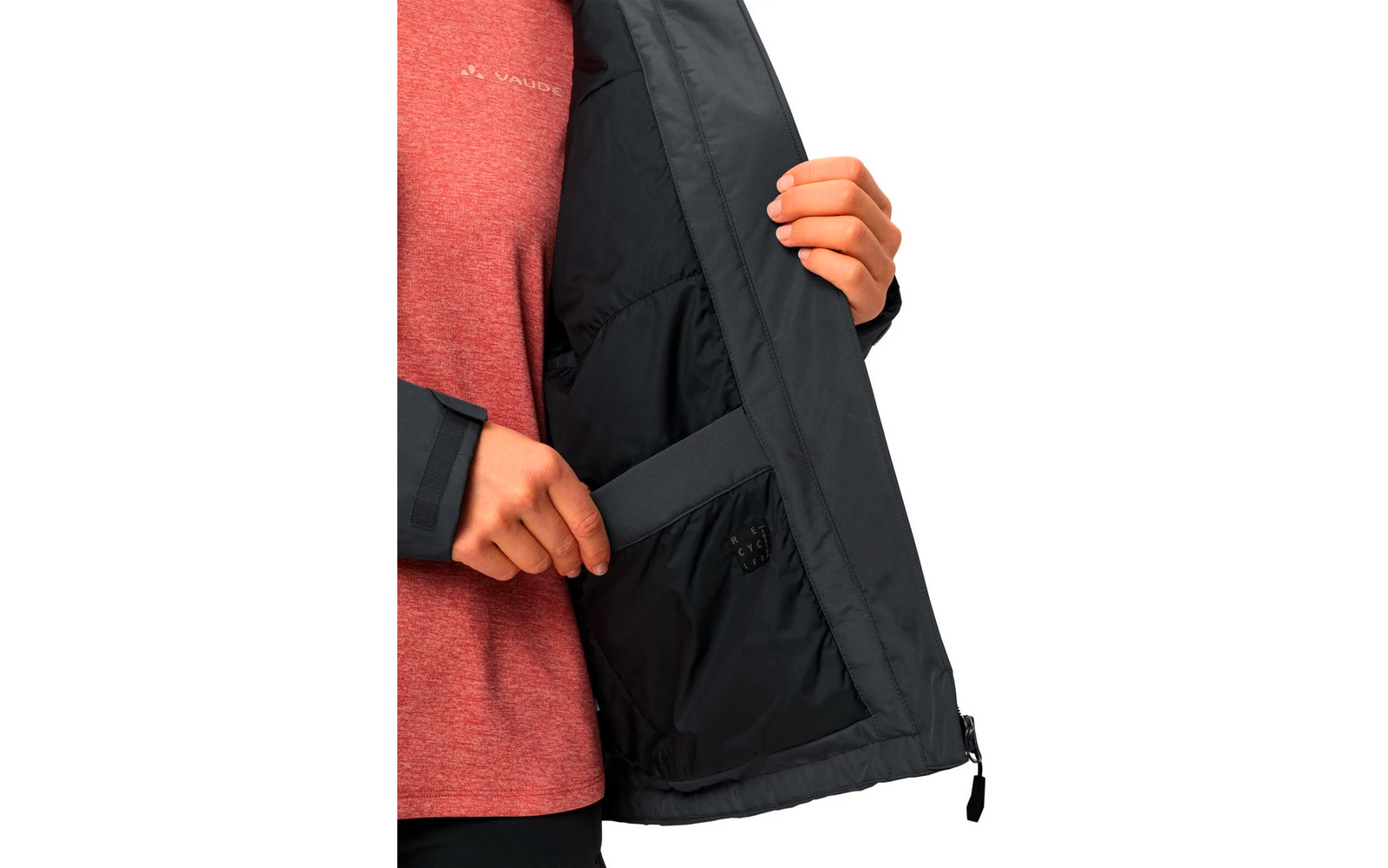 Person öffnet die Innenseite einer schwarzen Jacke, trägt roten Pullover