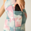 Hand placing a smartphone into the side pocket of pastel-colored leggings