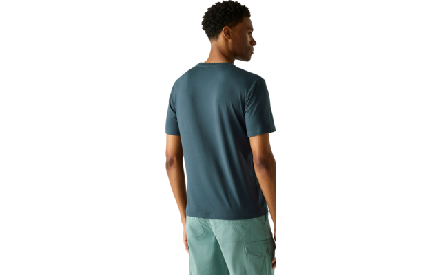 Person von hinten, trägt blaugrünes T-Shirt und hellgrüne Shorts, steht mit dem Kopf nach rechts gedreht