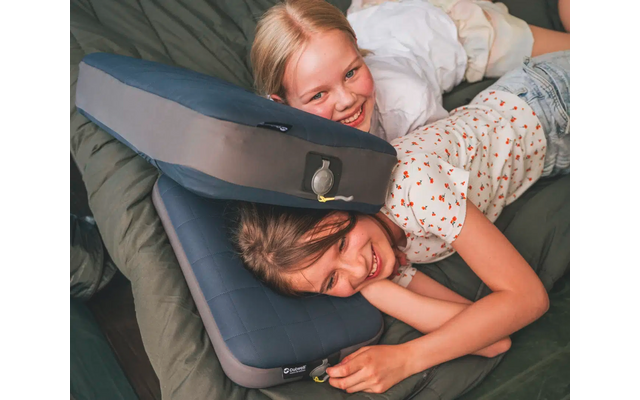 Due bambini sdraiati su un materasso con cuscini d'aria compressa, sorridenti