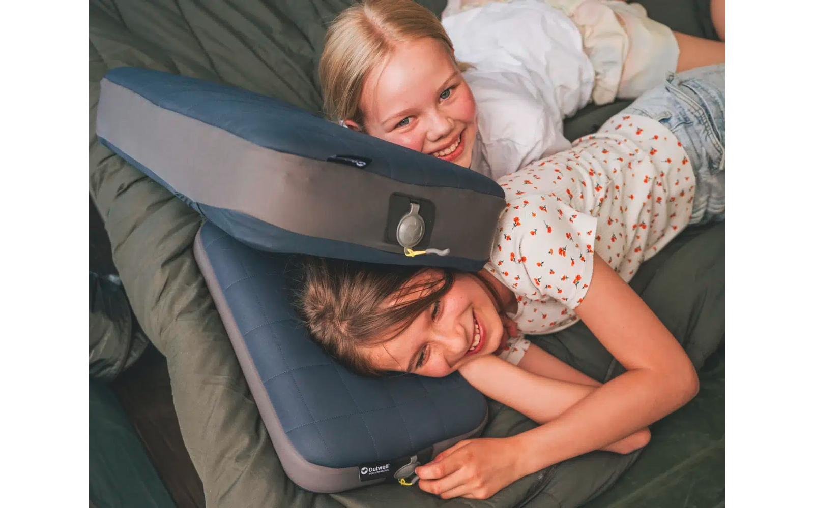 Due bambini sdraiati su un materasso con cuscini d'aria compressa, sorridenti