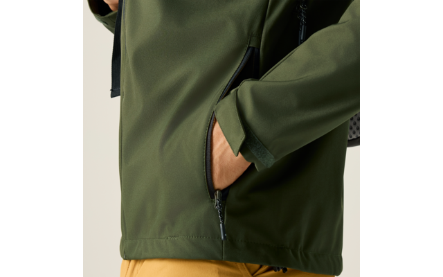 Hand steckt in Reißverschlusstasche einer olivgrünen Jacke; gelbe Hose sichtbar