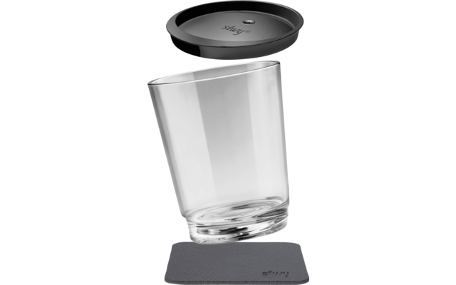 Schräg stehendes durchsichtiges Glas mit schwarzem Deckel darüber und quadratischer grauer Unterlage darunter