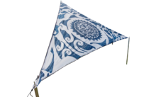 Driehoekig zeil met blauw patroon op een weiland, bomen en blauwe lucht op de achtergrond