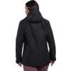 Person von hinten mit dunkel schulterlangem Haar, schwarzer Kapuzenjacke und bordeauxroter Hose vor weißem Hintergrund